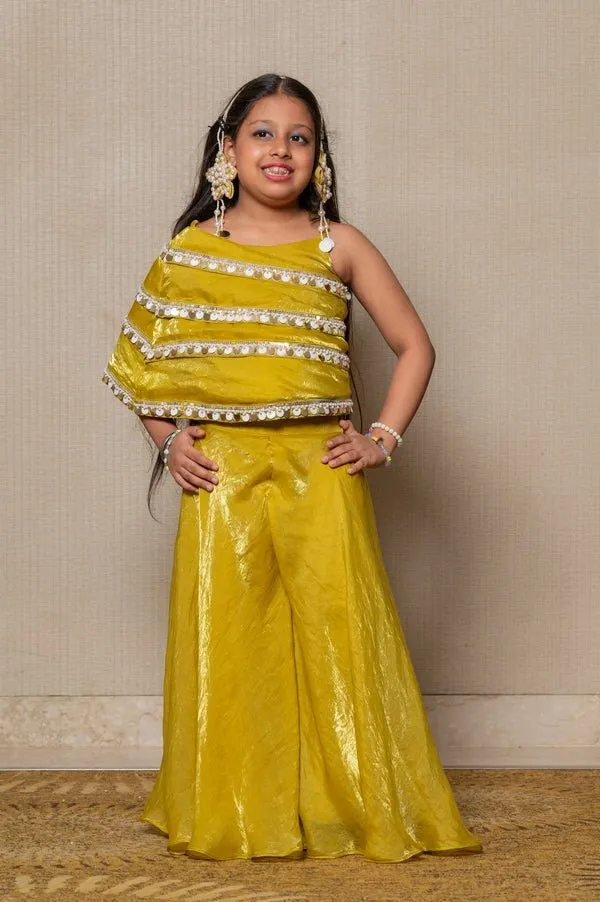 Vibrant golden-yellow ensemble with an asymmetrical top and wide-legged pants, perfect for making a bold statement at any festive occasion.